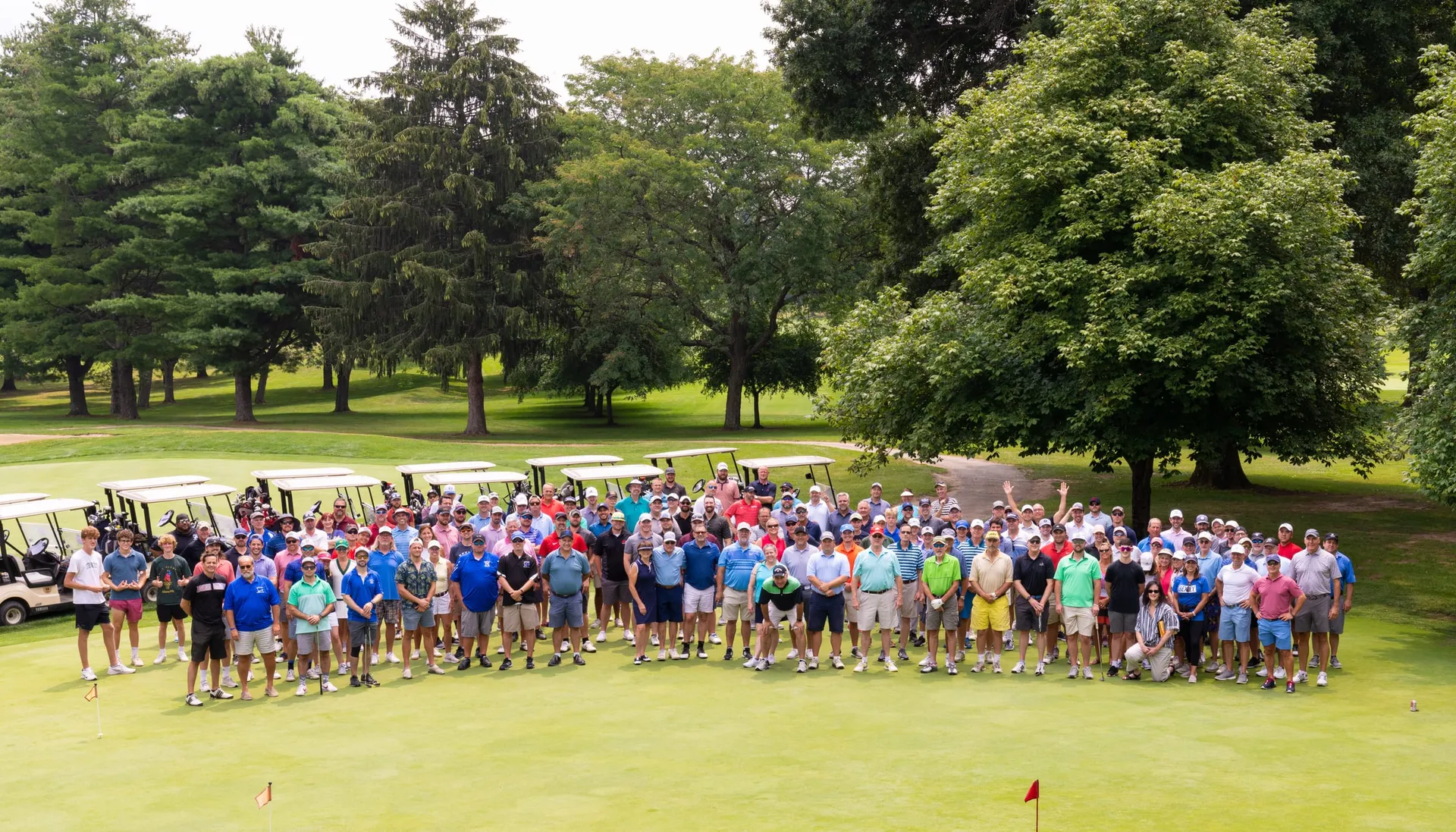 A large group of golfers gathered on the green at the Boosters golf outing